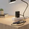Airox AD-22 45W fast charging adapter plugged in, charging a smartphone on a wooden desk.