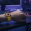 Person wearing gold Crown M60 Ultra 2 Smart Watch with metal strap at a gaming computer desk setup.