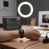 D20 Bluetooth Smart Band on wrist showing time, heart rate, steps at a desk with laptop and ring light.